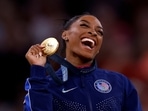 Gold medallist Simone Biles of United States celebrates on the podium with her medal. 