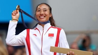 Gold medallist Qinwen Zheng of China poses with her medal. (REUTERS)