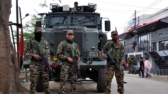 FILE PHOTO: Security personnel stand guard in front of their armoured vehicle outside a polling station during a rerun voting at 11 polling stations, in Imphal, Manipur, India, April 22, 2024. REUTERS/Stringer/File Photo