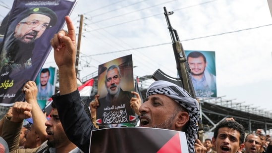 Protesters hold posters of Hezbollah senior commander Fuad Shukr and assassinated Hamas chief Ismail Haniyeh and Houthi leader Abdul-Malik al-Houthi during a protest to show solidarity with Palestinian prisoners in Sanaa, Yemen on August 3.(Reuters)