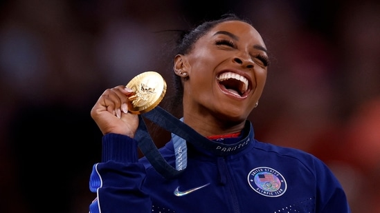 Gold medallist Simone Biles of United States celebrates on the podium with her medal.