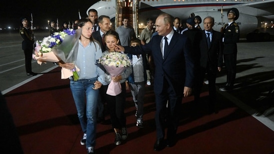 The image shows Russian President Vladimir Putin with one of the kids of the two Russian sleeper agents who were flown to Moscow. (AFP)