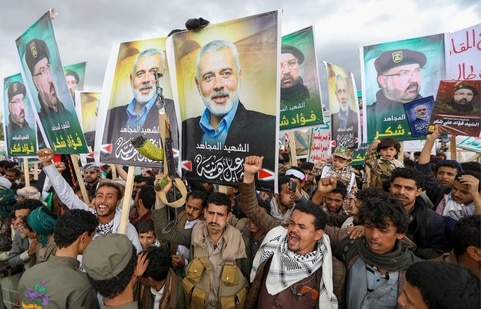 Middle East Crisis Live Updates: Yemenis wave flags and lift placards of Hezbollah senior commander Fuad Shukr, who was killed in an Israeli strike, and slain Hamas chief Ismail Haniyeh, during a rally in the Huthi-controlled capital Sanaa on August 2. 