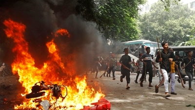 Men run past a burning vehicle inside the Bangabandhu Sheikh Mujib Medical University Hospital, set on fire by protesters, during a rally against Prime Minister Sheikh Hasina and her government demanding justice for the victims killed in the recent countrywide deadly clashes, in Dhaka, Bangladesh, Sunday, Aug. 4, 2024. (AP/PTI) Men run past a burning vehicle inside the Bangabandhu Sheikh Mujib Medical University Hospital, set on fire by protesters, during a rally against Prime Minister Sheikh Hasina and her government demanding justice for the victims killed in the recent countrywide deadly clashes, in Dhaka, Bangladesh, Sunday, Aug. 4, 2024. (AP/PTI)