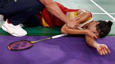 Spain's Carolina Marin plays reacts as she falls during an injury in her women's singles badminton semi-final match against China's He Bing Jiao during the Paris 2024 Olympic Games at Porte de la Chapelle Arena (AFP)