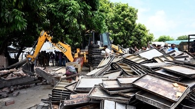 A bulldozer being used to demolish the bakery of Moid Khan who is accused of allegedly raping a 12-year-old girl, in Ayodhya on August 3. (PTI) A bulldozer being used to demolish the bakery of Moid Khan who is accused of allegedly raping a 12-year-old girl, in Ayodhya on August 3. (PTI)