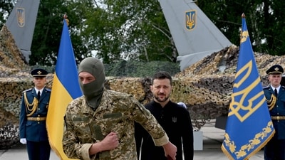 TOPSHOT - Ukraine's President Volodymyr Zelensky (C/R) stands in front of a pair of F16 fighter jets after giving an award to a Ukranian fighter pilot during Ukrainian Air Forces Day at an undisclosed location on August 4, 2024. (Photo by Sergei SUPINSKY / AFP) TOPSHOT - Ukraine's President Volodymyr Zelensky (C/R) stands in front of a pair of F16 fighter jets after giving an award to a Ukranian fighter pilot during Ukrainian Air Forces Day at an undisclosed location on August 4, 2024. (Photo by Sergei SUPINSKY / AFP)