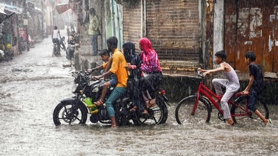 People commute amid heavy rainfall, in Prayagraj on Saturday. (ANI Photo)