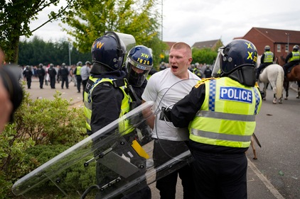 Police officers lead a man away during an anti-immigration demonstration outside the Holiday Inn Express in Rotherham, England, Sunday Aug. 4, 2024. (AP) Police officers lead a man away during an anti-immigration demonstration outside the Holiday Inn Express in Rotherham, England, Sunday Aug. 4, 2024. (AP)