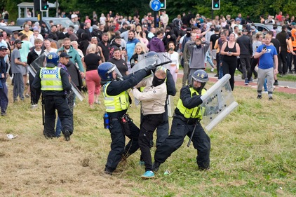 Police officers grapple with a man during an anti-immigration demonstration outside the Holiday Inn Express in Rotherham, England, Sunday Aug. 4, 2024. (AP) Police officers grapple with a man during an anti-immigration demonstration outside the Holiday Inn Express in Rotherham, England, Sunday Aug. 4, 2024. (AP)