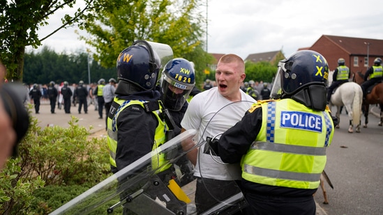 Police officers lead a man away during an anti-immigration demonstration outside the Holiday Inn Express in Rotherham, England, Sunday Aug. 4, 2024.(AP)