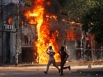 Men run past a shopping center which was set on fire by protesters during a rally against Prime Minister Sheikh Hasina and her government demanding justice for the victims killed in the recent countrywide deadly clashes in Dhaka, on Sunday. Men run past a shopping center which was set on fire by protesters during a rally against Prime Minister Sheikh Hasina and her government demanding justice for the victims killed in the recent countrywide deadly clashes in Dhaka, on Sunday.