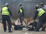 Police dogs attack a man during an anti-immigration protest in Rotherham, Britain. 