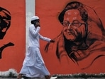 In this photo taken on December 16, 2018 a man walks past a wall with images of Bangladeshi founding father Sheikh Mujibur Rahman (L) and Sheikh Hasina Wazed (R) (Photo by REHMAN ASAD / AFP) In this photo taken on December 16, 2018 a man walks past a wall with images of Bangladeshi founding father Sheikh Mujibur Rahman (L) and Sheikh Hasina Wazed (R) (Photo by REHMAN ASAD / AFP)