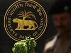 A police officer walks past the Reserve Bank of India (RBI) logo inside its headquarters in Mumbai, India.