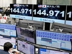 An employee of the foreign exchange trading company Gaitame.com works in front of monitors displaying the Japanese yen exchange rate against the US dollar. 