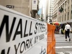 Pedestrians walk along Wall Street near the New York Stock Exchange (NYSE) in New York, US. Pedestrians walk along Wall Street near the New York Stock Exchange (NYSE) in New York, US.