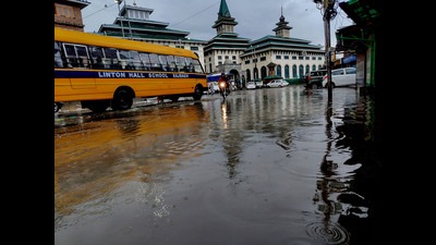 A school bus carrying students cross a waterlogged road following heavy rainfall, in Srinagar on Monday. (ANI)