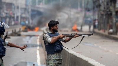 Bangladesh crisis: A policeman aims his weapon at protesters during a curfew imposed following violence during protests against Prime Minister Sheikh Hasina and her government, in Dhaka, Bangladesh. (AP)