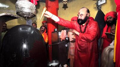 Head priest Mahant Deependra Giri performing ‘Jal Abhishek’ on the Shivling at the Shankaracharya Temple as part of the Amarnath Yatra, in Srinagar on Sunday. (ANI Photo)
