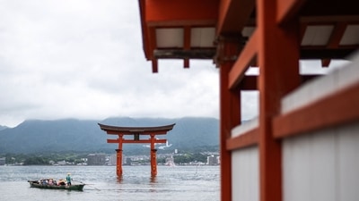 Tourists travel on a sightseeing boad sailing in front of the torii of Itsukushima Shrine (back), the popular tourist destination of Miyajima island in Hiroshima Prefecture. (Photo by Philip FONG / AFP) Tourists travel on a sightseeing boad sailing in front of the torii of Itsukushima Shrine (back), the popular tourist destination of Miyajima island in Hiroshima Prefecture. (Photo by Philip FONG / AFP)