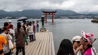 Tourists gather in front of torii of Itsukushima Shrine (back), the popular tourist destination of Miyajima island in Hiroshima Prefecture. (Photo by Philip FONG / AFP) Tourists gather in front of torii of Itsukushima Shrine (back), the popular tourist destination of Miyajima island in Hiroshima Prefecture. (Photo by Philip FONG / AFP)
