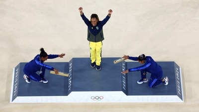 Gold medallist Rebeca Andrade of Brazil celebrates with silver medallist Simone Biles of United States and bronze medallist Jordan Chiles of United States on the podium (REUTERS)