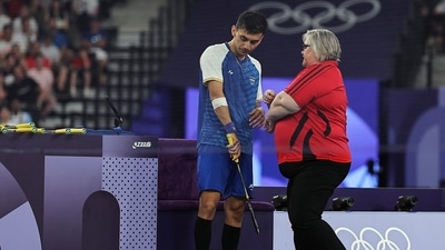 Lakshya Sen of India receives medical attention after sustaining an elbow injury during the match against Zii Jia Lee of Malaysia. (REUTERS)
