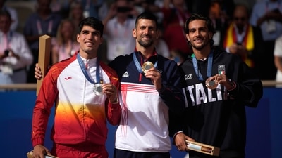 Serbia's Novak Djokovic , center, gold medalist, Spain's Carlos Alcaraz, left, silver medalist, and Italian bronze medalist Lorenzo Musetti pose on the podium, (AP) Serbia's Novak Djokovic , center, gold medalist, Spain's Carlos Alcaraz, left, silver medalist, and Italian bronze medalist Lorenzo Musetti pose on the podium, (AP)