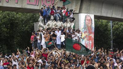 Protesters climb a public monument as they celebrate the news of Prime Minister Sheikh Hasina's resignation, in Dhaka, Bangladesh, on Monday. (AP) Protesters climb a public monument as they celebrate the news of Prime Minister Sheikh Hasina's resignation, in Dhaka, Bangladesh, on Monday. (AP)