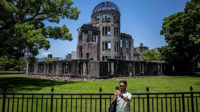 A man takes pictures in front of Hiroshima Prefectural Industrial Promotion Hall, commonly known as the atomic bomb dome in Hiroshima. August 6, 2024, observed solemnly as Hiroshima Day around the world, will be the 79th anniversary of the atomic bombing of the Japanese city in the final year of World War II as on this day in 1945, the United States dropped the very first deployed nuclear bomb in the city of Hiroshima, wiping out an estimated 39 percent of the population, most of who were civilians. Today, Hiroshima Prefectural stands as a poignant symbol of peace and resilience and visiting Hiroshima Prefectural on Hiroshima Day is not just a journey through history; it is an immersive experience that blends solemn remembrance with a powerful message of hope for future generations. Trips and tours to Hiroshima Prefectural provide a deeper understanding of Hiroshima's transformation from a site of tragedy to a beacon of peace - (Photo by Philip FONG / AFP) A man takes pictures in front of Hiroshima Prefectural Industrial Promotion Hall, commonly known as the atomic bomb dome in Hiroshima. August 6, 2024, observed solemnly as Hiroshima Day around the world, will be the 79th anniversary of the atomic bombing of the Japanese city in the final year of World War II as on this day in 1945, the United States dropped the very first deployed nuclear bomb in the city of Hiroshima, wiping out an estimated 39 percent of the population, most of who were civilians. Today, Hiroshima Prefectural stands as a poignant symbol of peace and resilience and visiting Hiroshima Prefectural on Hiroshima Day is not just a journey through history; it is an immersive experience that blends solemn remembrance with a powerful message of hope for future generations. Trips and tours to Hiroshima Prefectural provide a deeper understanding of Hiroshima's transformation from a site of tragedy to a beacon of peace - (Photo by Philip FONG / AFP)