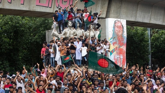 Protesters climb a public monument as they celebrate after getting the news of Prime Minister Sheikh Hasina's resignation, in Dhaka, Bangladesh, Monday, Aug. 5, 2024.(AP)