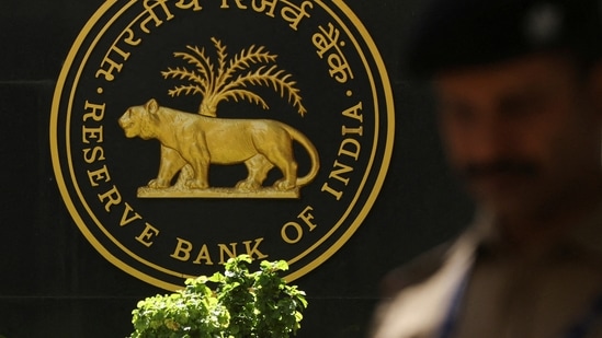 A police officer walks past the Reserve Bank of India (RBI) logo inside its headquarters in Mumbai, India.(Reuters)