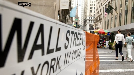 Pedestrians walk along Wall Street near the New York Stock Exchange (NYSE) in New York, US.(Bloomberg)