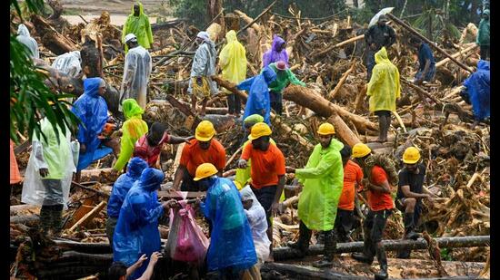 TOPSHOT - Relief personnel carry the body of a victim, during a search and rescue operation at a site following landslides in Wayanad on July 30, 2024. (Photo by R. J. Mathew / AFP) (AFP)