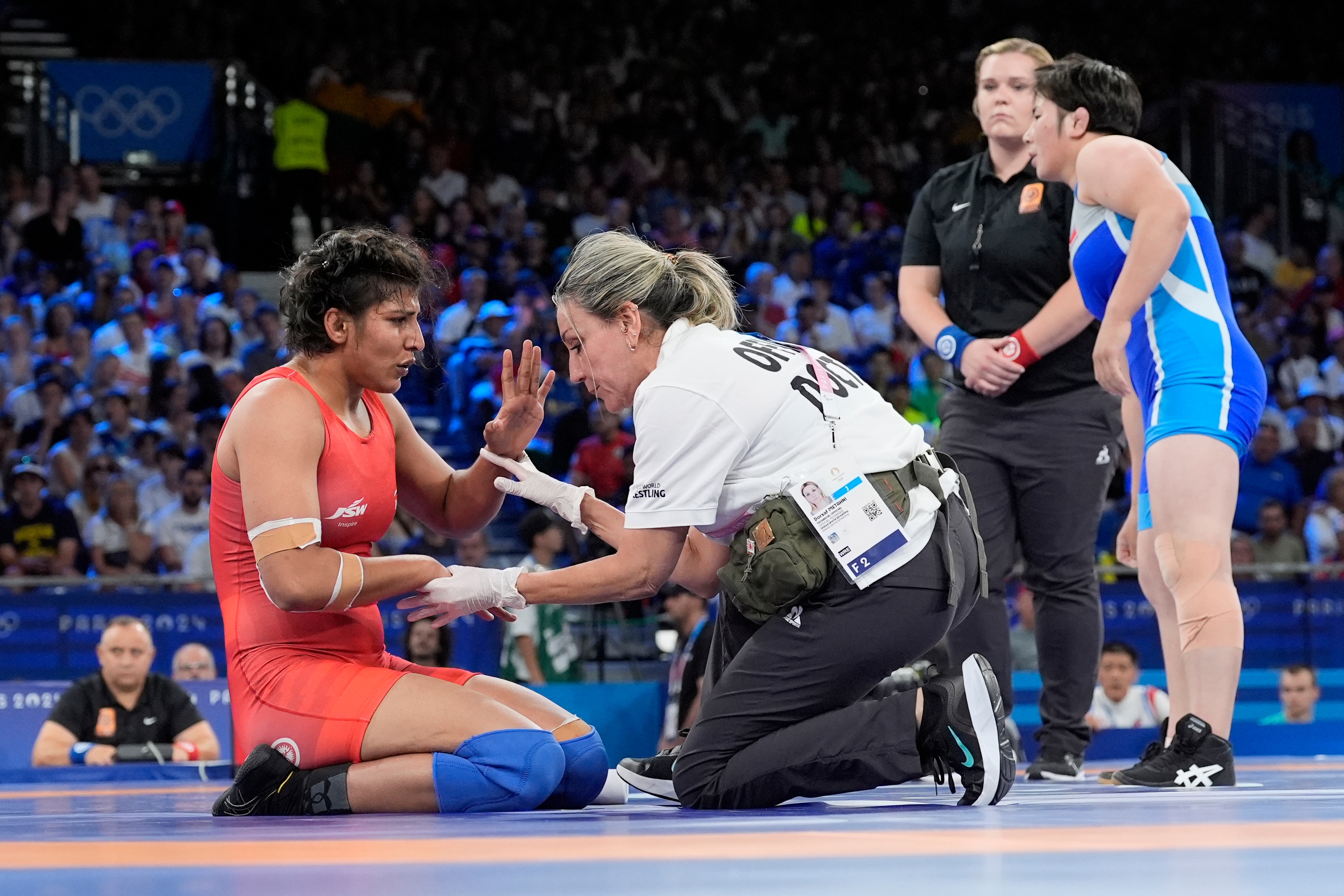 India's Nisha Dahiya receives medical attention during their women's freestyle 68kg wrestling quarterfinal match (AP) India's Nisha Dahiya receives medical attention during their women's freestyle 68kg wrestling quarterfinal match (AP)