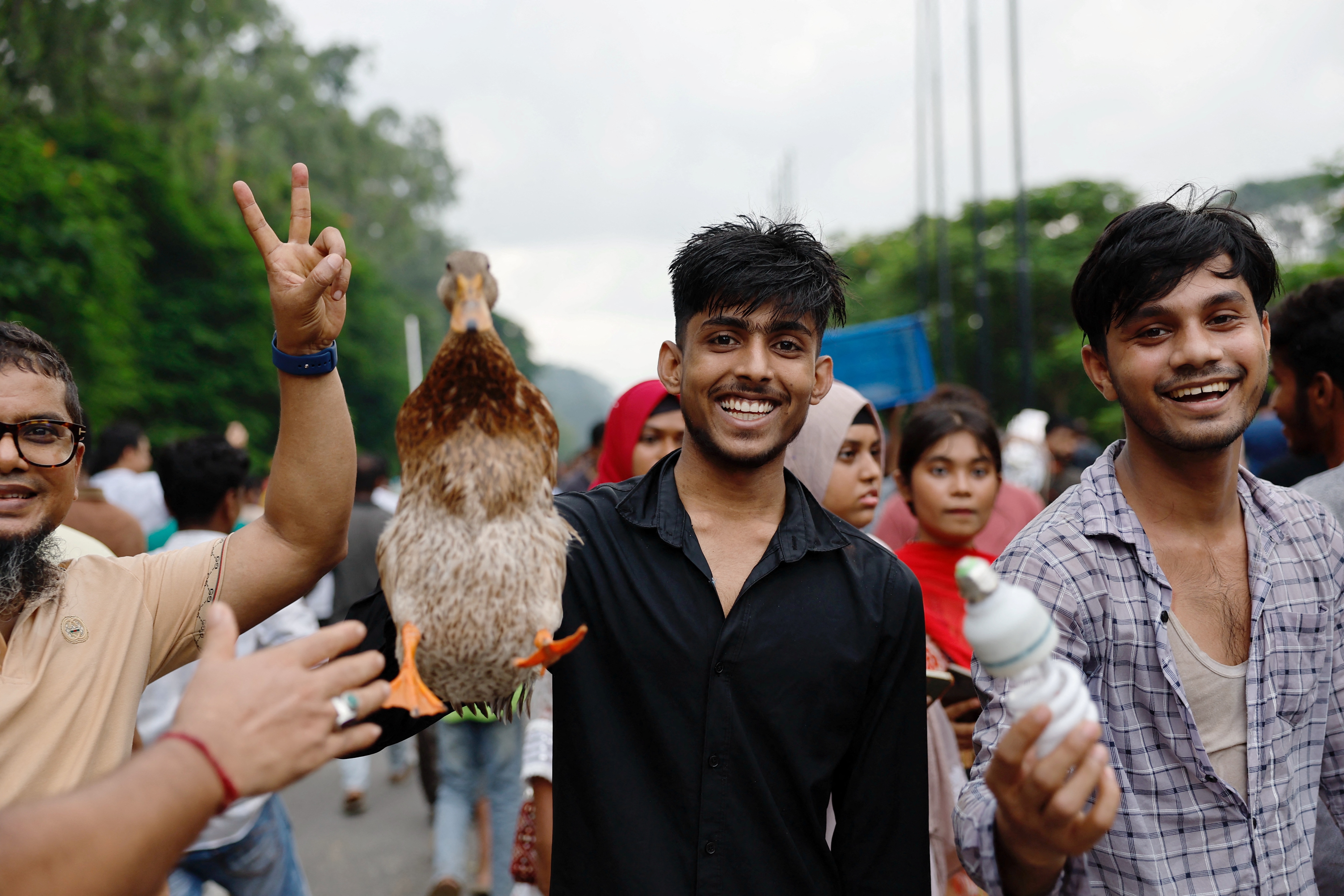 People remove a live duck and an electric bulb from the Ganabhaban, the prime minister's residence, after the resignation of PM Sheikh Hasina in Dhaka. (Reuters)