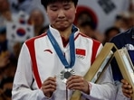 China's silver medallist He Bing Jiao reacts with her medal on the podium at the women's singles badminton medal ceremony during the Paris 2024 Olympic Games (AFP)