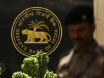 RBI MPC: A police officer walks past the Reserve Bank of India (RBI) logo inside its headquarters in Mumbai, India.