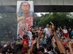 Protesters celebrate beside a defaced portrait of Prime Minister Sheikh Hasina after news of her resignation, in Dhaka, Bangladesh. (AP) Protesters celebrate beside a defaced portrait of Prime Minister Sheikh Hasina after news of her resignation, in Dhaka, Bangladesh. (AP)