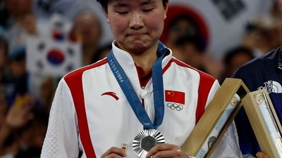 China's silver medallist He Bing Jiao reacts with her medal on the podium at the women's singles badminton medal ceremony during the Paris 2024 Olympic Games (AFP) China's silver medallist He Bing Jiao reacts with her medal on the podium at the women's singles badminton medal ceremony during the Paris 2024 Olympic Games (AFP)