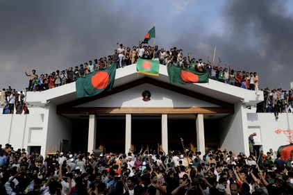 Anti-government protestors display Bangladesh's national flag as they storm the Prime Minister's palace in Dhaka. (AFP) Anti-government protestors display Bangladesh's national flag as they storm the Prime Minister's palace in Dhaka. (AFP)