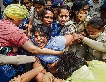 Security personnel detain wrestler Sakshi Malik during a protest march towards new Parliament building. (PTI) Security personnel detain wrestler Sakshi Malik during a protest march towards new Parliament building. (PTI)