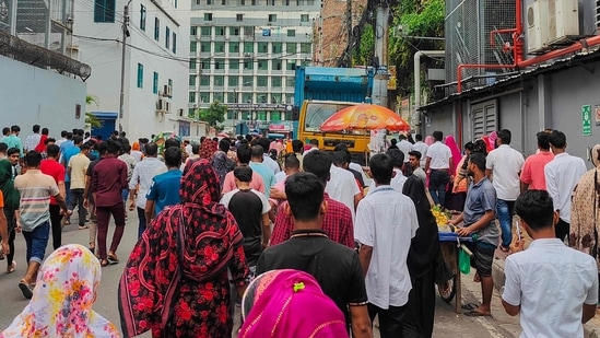 Pekerja garmen sedang istirahat makan siang selama jam kerja di Dhaka pada 24 Juli 2024. Pabrik garmen dan bank kembali dibuka di Bangladesh pada 24 Juli setelah pihak berwenang melonggarkan jam malam yang diberlakukan untuk meredam bentrokan mematikan yang dipicu oleh protes mahasiswa atas kuota pegawai negeri sipil. (Foto oleh Maruf Hasan / AFP)