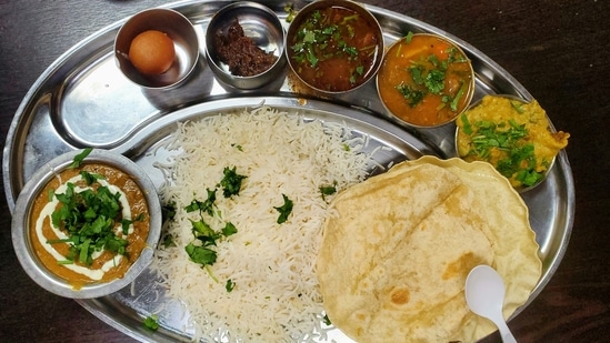 Western dining favours distinct courses, while Indian cuisine often serves a variety of dishes together on a thali. (Unsplash)