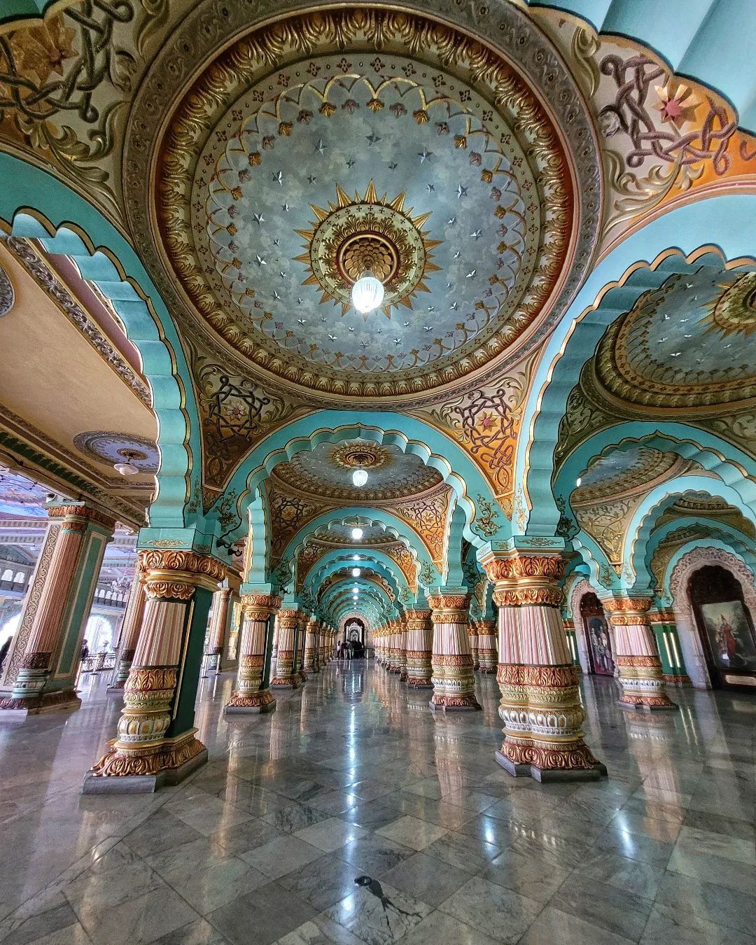 The Palace of Mysore is decorated in Indo-Sarcenic style architecture, with square towers at each corner covered with vibrant red domes. The Palace of Mysore is decorated in Indo-Sarcenic style architecture, with square towers at each corner covered with vibrant red domes.