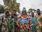 Visitor pose with an egungun, a character wearing a Yoruba costume and mask, during the grand procession of traditional masks in Porto-Novo. The Porto-Novo Mask Festival, which was held over three days, was created at the initiative of the Beninese government and the municipality, to replace the Porto-Novo International Festival usually held in January. During this new event, dozens of people wearing different masks from all over the country paraded, but also others from Togo and Burkina Faso were also exhibited on the main avenue of the city. (Photo by Yanick Folly / AFP) Visitor pose with an egungun, a character wearing a Yoruba costume and mask, during the grand procession of traditional masks in Porto-Novo. The Porto-Novo Mask Festival, which was held over three days, was created at the initiative of the Beninese government and the municipality, to replace the Porto-Novo International Festival usually held in January. During this new event, dozens of people wearing different masks from all over the country paraded, but also others from Togo and Burkina Faso were also exhibited on the main avenue of the city. (Photo by Yanick Folly / AFP)