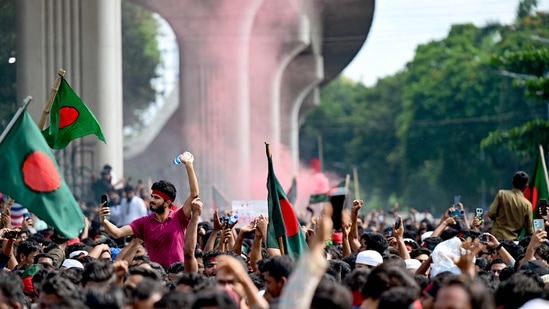 Anti-government protestors wave Bangladesh's national flag as they celebrate at Shahbag area, near Dhaka university in Dhaka on August 5, 2024.(AFP)