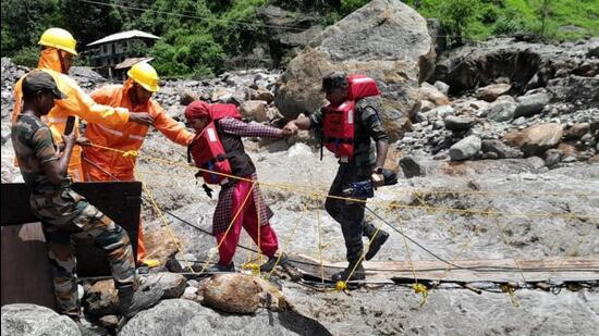 NDRF teams rescue residents stranded near the bank of a rivulet after heavy rainfall in Samej village, Himachal. (HT)