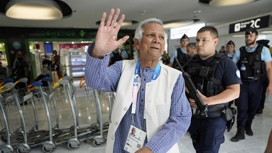 Nobel laureate Muhammad Yunus waves to the media at Charles de Gaulle's airport in Roissy, north of Paris, Wednesday. (AP)